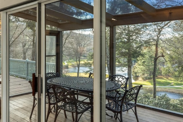 sunroom / solarium featuring a healthy amount of sunlight, a skylight, and a water view