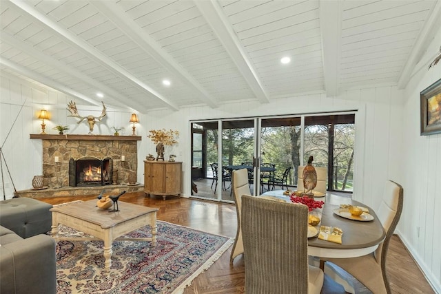 living room with recessed lighting, a stone fireplace, and vaulted ceiling with beams