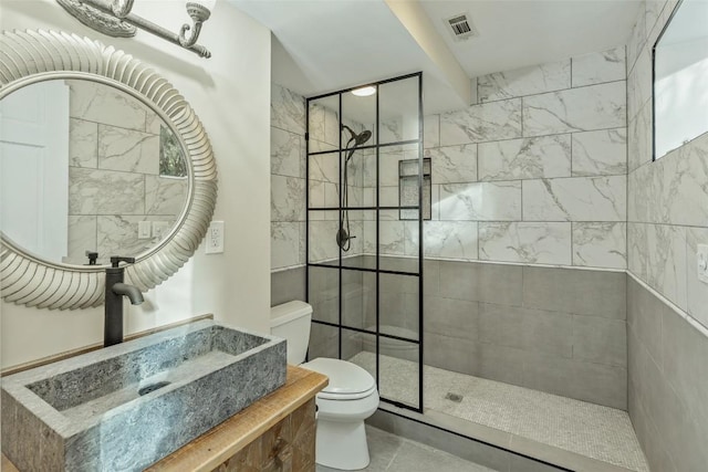 bathroom with visible vents, a walk in shower, toilet, and a sink