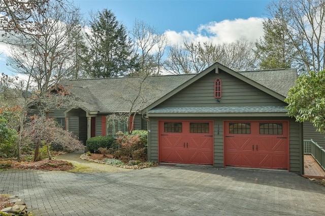 view of front of property featuring driveway, a shingled roof, and an attached garage