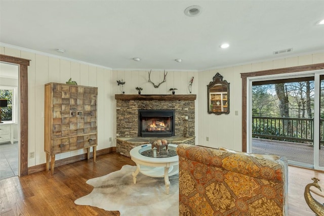 living room with plenty of natural light, wood finished floors, and ornamental molding