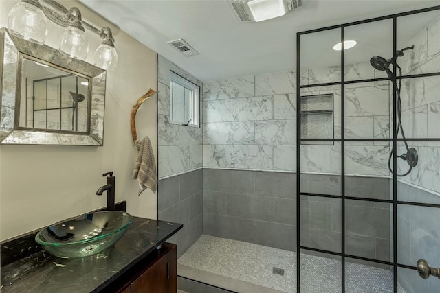 bathroom with vanity, visible vents, and walk in shower