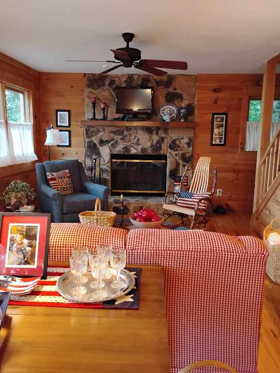 172 Moon Ridge Dr, Sky Valley, GA 30537 - living area featuring ceiling fan, wood finished floors, wood walls, a fireplace, and stairs