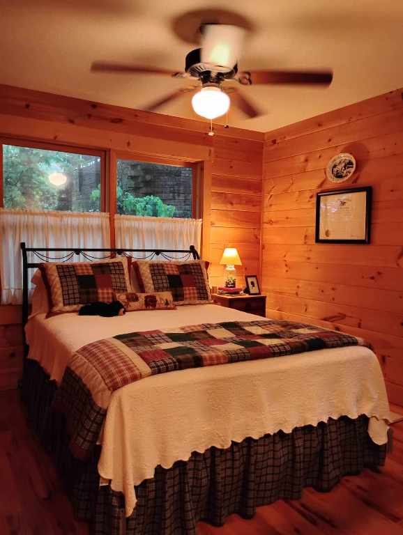 172 Moon Ridge Dr, Sky Valley, GA 30537 - bedroom featuring wood finished floors, wood walls, and ceiling fan