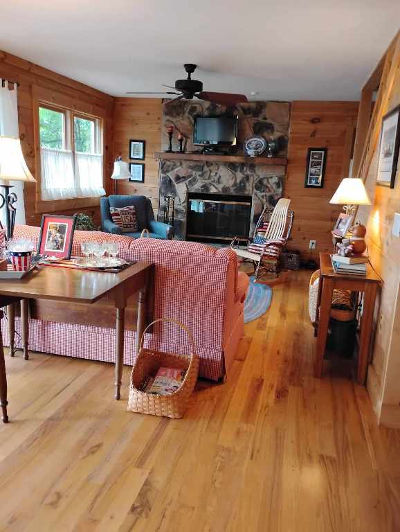 172 Moon Ridge Dr, Sky Valley, GA 30537 - living room featuring a ceiling fan, a fireplace, wood finished floors, and wooden walls