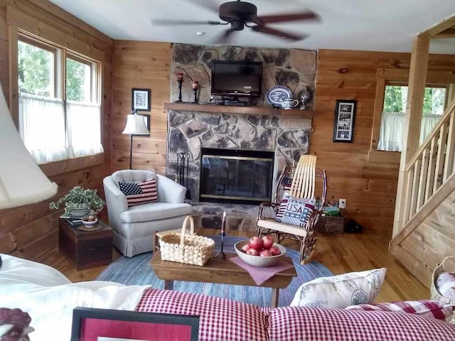 172 Moon Ridge Dr, Sky Valley, GA 30537 - living room with wood finished floors, wood walls, a ceiling fan, a stone fireplace, and stairway