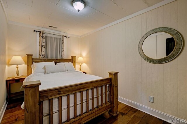 bedroom with dark wood-type flooring and ornamental molding