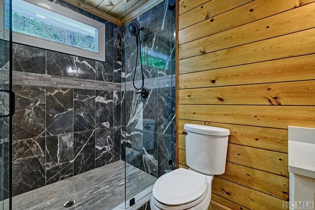 bathroom featuring tiled shower, toilet, and wood walls