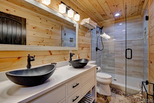 bathroom with wooden walls, vanity, walk in shower, wood ceiling, and toilet