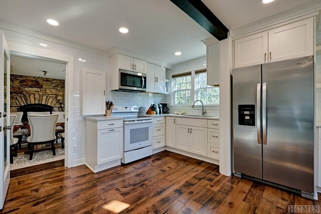 kitchen with stainless steel appliances, white cabinetry, sink, and dark hardwood / wood-style floors