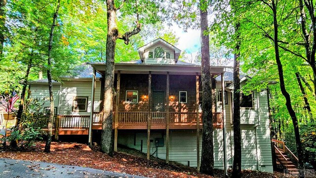 back of property featuring a wooden deck and a sunroom