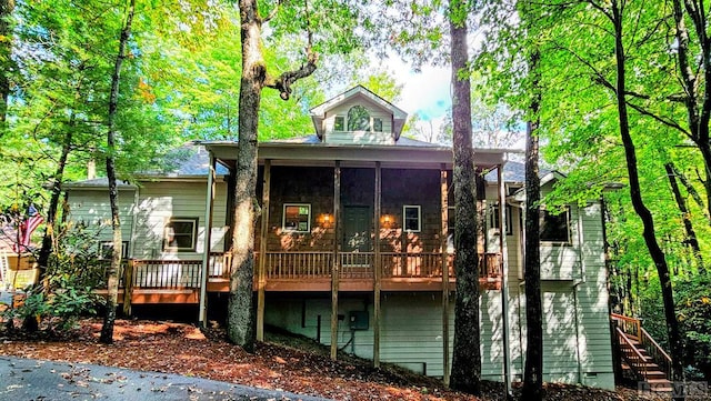 back of property with a deck and a sunroom