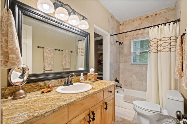 full bathroom featuring shower / bath combo with shower curtain, toilet, and vanity