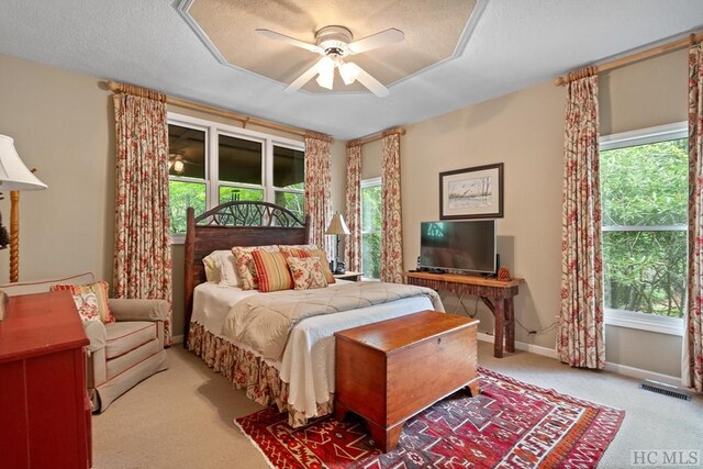 carpeted bedroom featuring ceiling fan and a textured ceiling