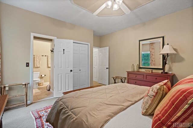 carpeted bedroom with ceiling fan and connected bathroom