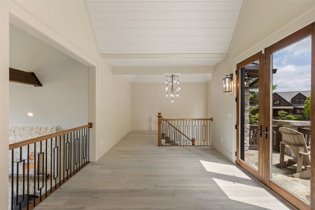 494 E Ridge Rd, Cashiers, NC 28717 - hall featuring light wood-style floors, vaulted ceiling, an upstairs landing, baseboards, and a chandelier