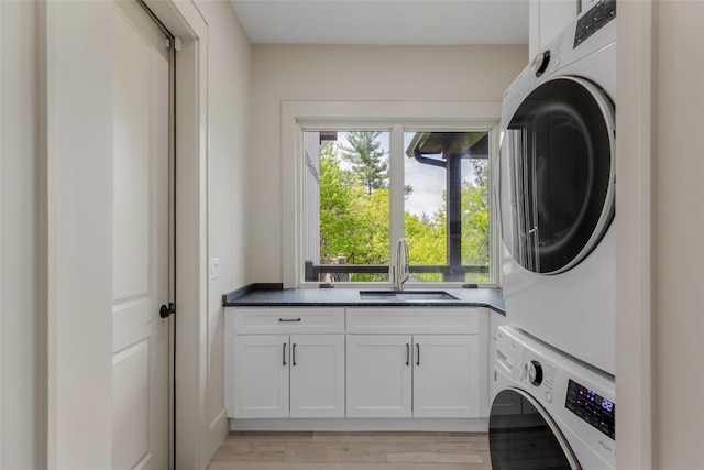 494 E Ridge Rd, Cashiers, NC 28717 - laundry room with stacked washing machine and dryer, cabinet space, and light wood-style flooring