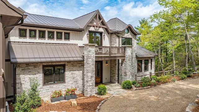 494 E Ridge Rd, Cashiers, NC 28717 - view of front of house featuring a standing seam roof, metal roof, a balcony, and stone siding