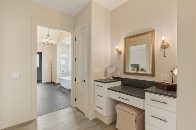494 E Ridge Rd, Cashiers, NC 28717 - bathroom featuring a freestanding tub, wood finished floors, vanity, and a chandelier