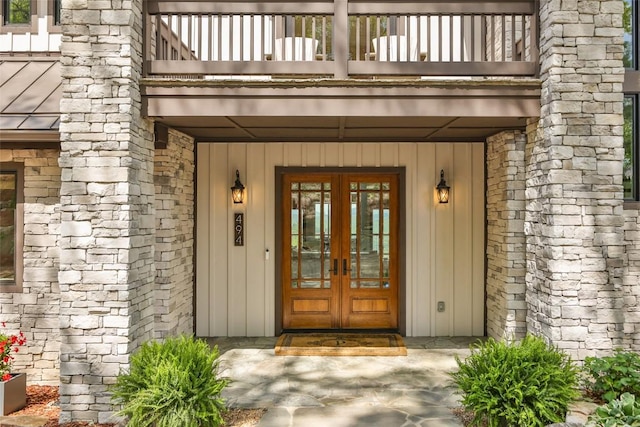 494 E Ridge Rd, Cashiers, NC 28717 - view of exterior entry featuring a balcony, french doors, stone siding, and board and batten siding