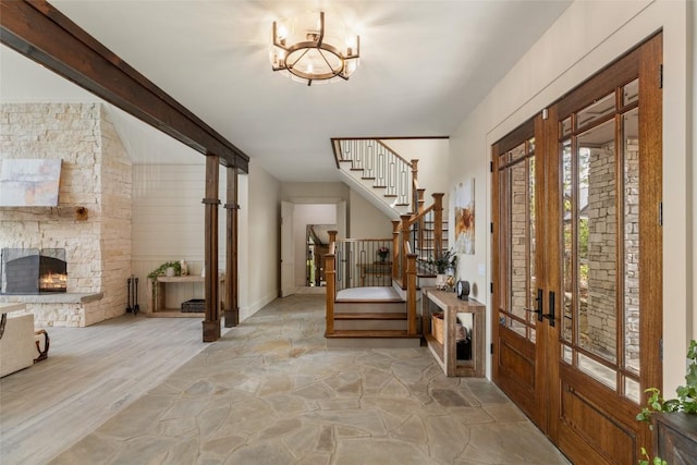 494 E Ridge Rd, Cashiers, NC 28717 - foyer featuring stairs, french doors, a chandelier, stone floors, and a fireplace