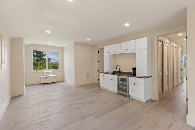 494 E Ridge Rd, Cashiers, NC 28717 - indoor wet bar featuring beverage cooler, baseboards, light wood-style floors, and recessed lighting