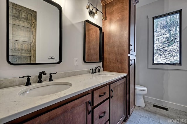 bathroom featuring vanity, tile patterned flooring, and toilet