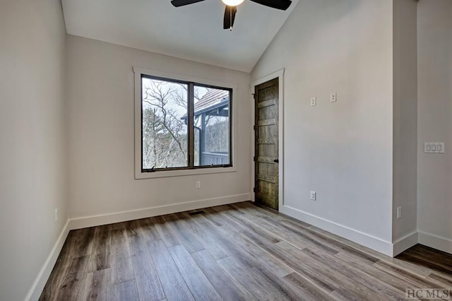 spare room featuring lofted ceiling, ceiling fan, and light wood-type flooring