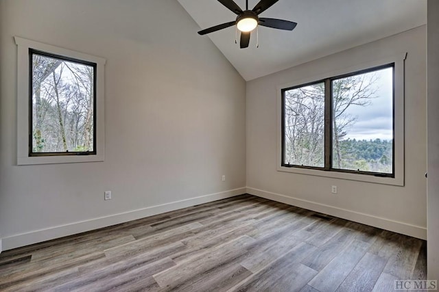 unfurnished room with plenty of natural light, vaulted ceiling, and light hardwood / wood-style flooring