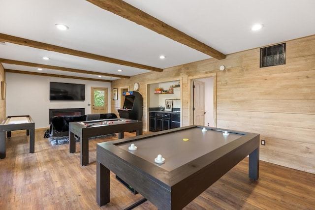 recreation room featuring wood finished floors, a fireplace, recessed lighting, beamed ceiling, and wooden walls
