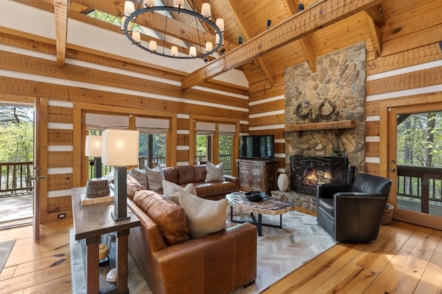 living room featuring light wood finished floors, wooden ceiling, beam ceiling, a fireplace, and wood walls