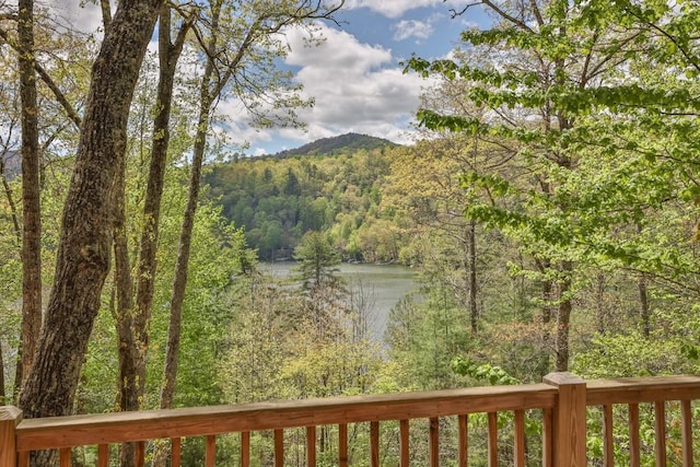 mountain view featuring a heavily wooded area and a nearby body of water