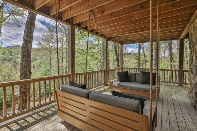 deck featuring an outdoor hangout area and a wooded view