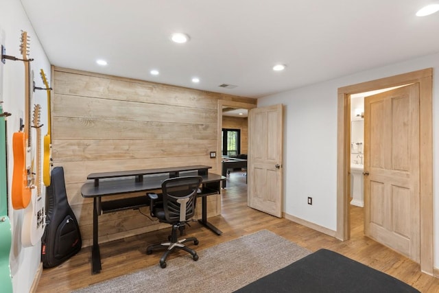 office featuring recessed lighting, wood finished floors, baseboards, and wooden walls