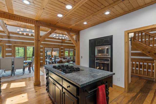 kitchen featuring stainless steel appliances, a chandelier, light wood-style flooring, wooden ceiling, and open floor plan