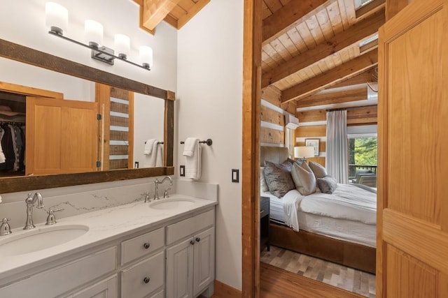 ensuite bathroom featuring wood ceiling, wood finished floors, and double vanity