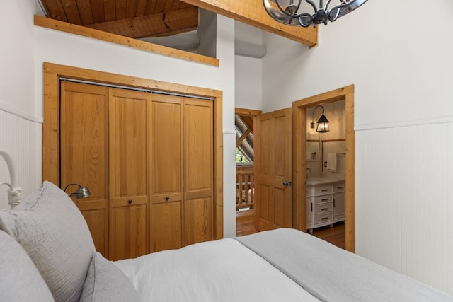 bedroom featuring wainscoting, a chandelier, wood finished floors, and wood ceiling