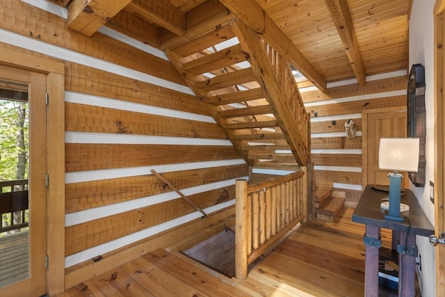stairs with hardwood / wood-style flooring and beam ceiling