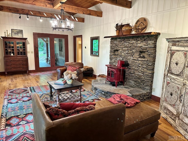 living room with a notable chandelier, beam ceiling, wood-type flooring, and track lighting