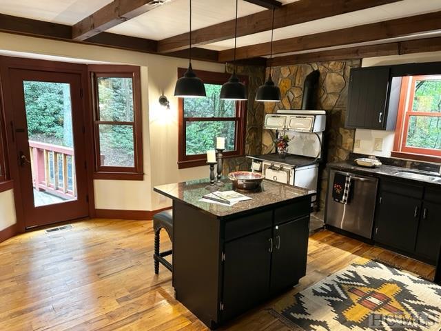 kitchen featuring sink, dishwasher, hanging light fixtures, beam ceiling, and a center island