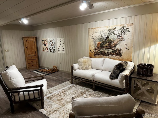 living room with crown molding, wood-type flooring, and wooden walls