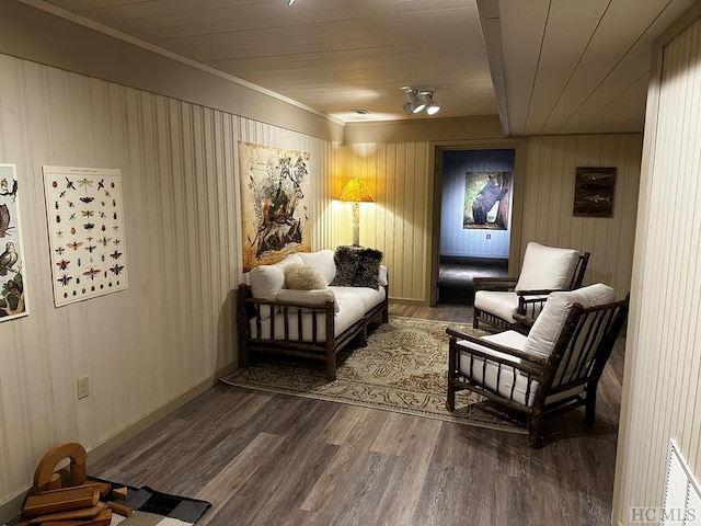 sitting room featuring wood-type flooring, ornamental molding, and wooden ceiling