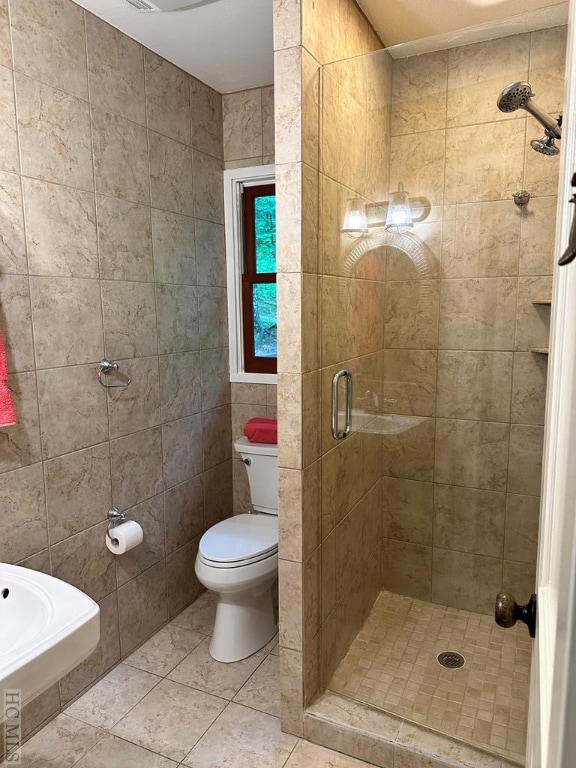 bathroom with tile patterned floors, a shower with door, and toilet