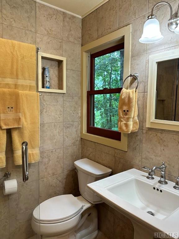 bathroom with sink, tile walls, decorative backsplash, and toilet