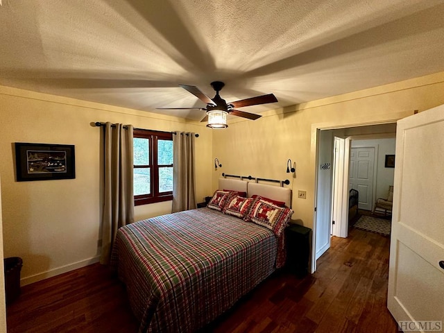 bedroom with ceiling fan, dark hardwood / wood-style floors, and a textured ceiling