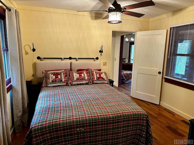 bedroom with ceiling fan and dark hardwood / wood-style floors