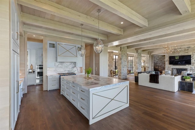 893 High Mountain Dr, Cashiers, NC 28717 - kitchen with a fireplace, dark wood-type flooring, white cabinetry, open floor plan, and tasteful backsplash