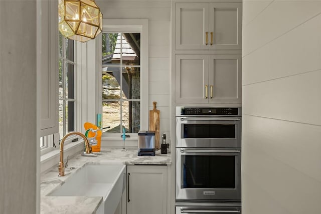 893 High Mountain Dr, Cashiers, NC 28717 - kitchen with double oven, a sink, a chandelier, and light stone countertops