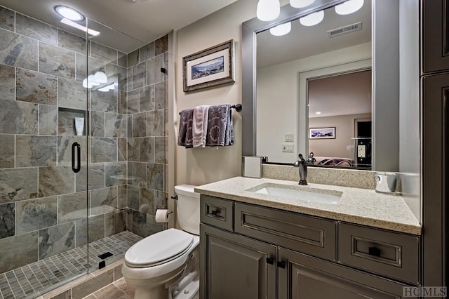 bathroom with toilet, vanity, and walk in shower