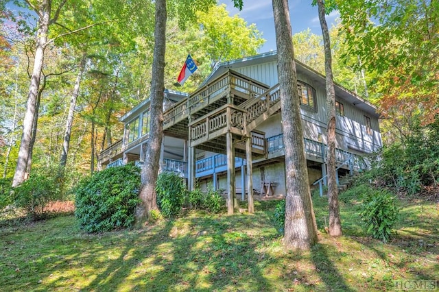 rear view of house featuring a deck and a lawn